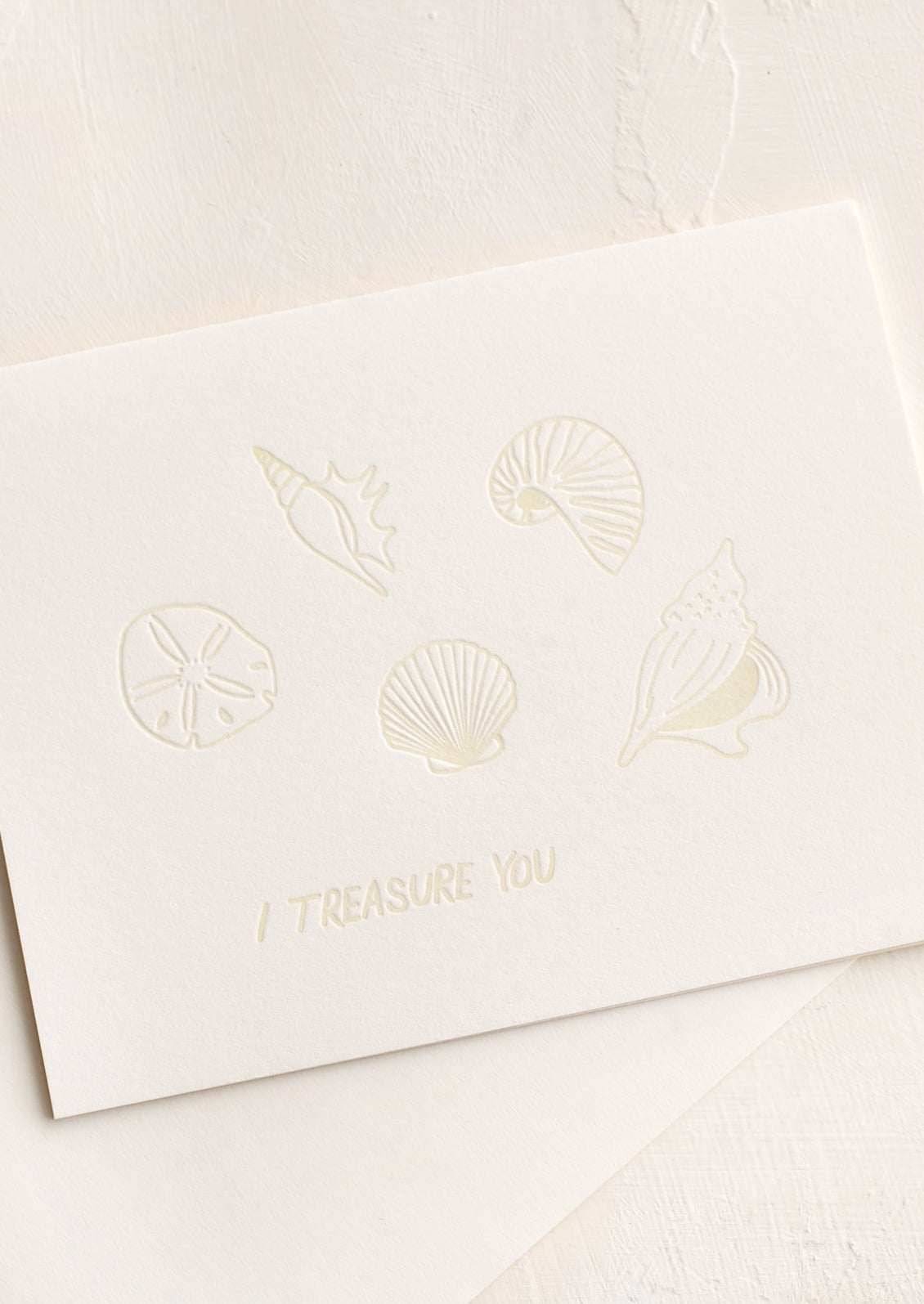 A greeting card with seashells and text reading "I treasure you".