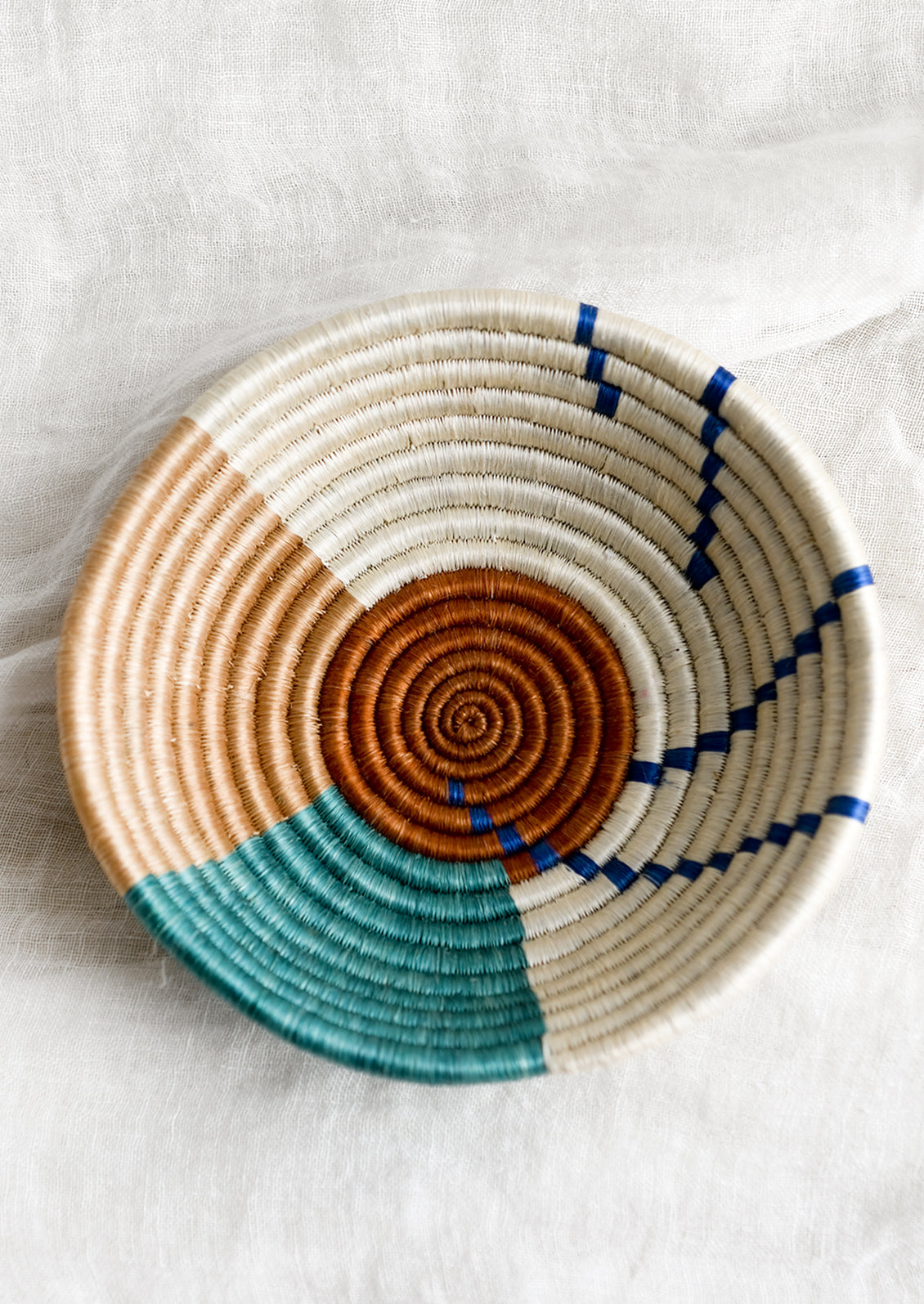 A round sweetgrass bowl in amber pattern.