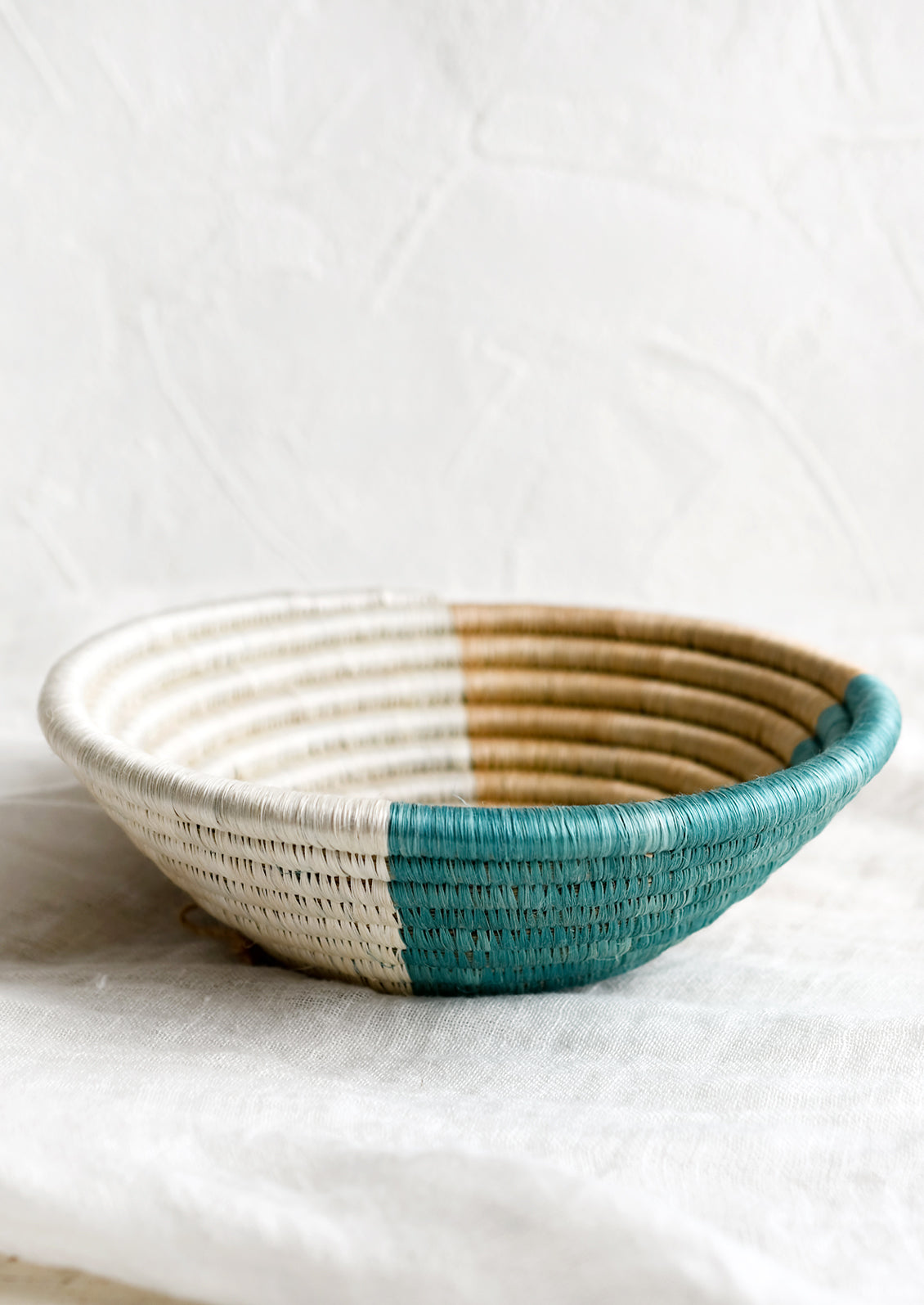 A round sweetgrass bowl in navy pattern.