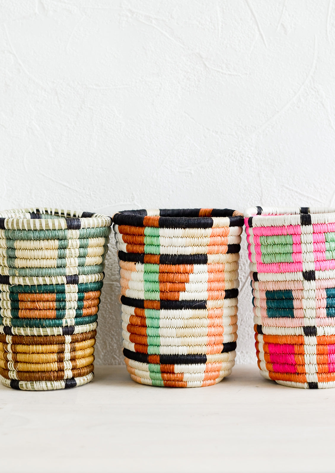 Pencil cup shaped baskets woven from multicolor sweetgrass.