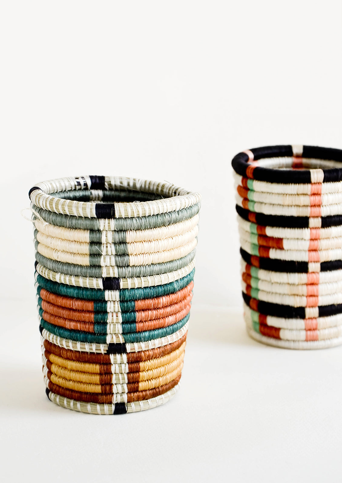 Pencil cup shaped baskets woven from multicolor sweetgrass.