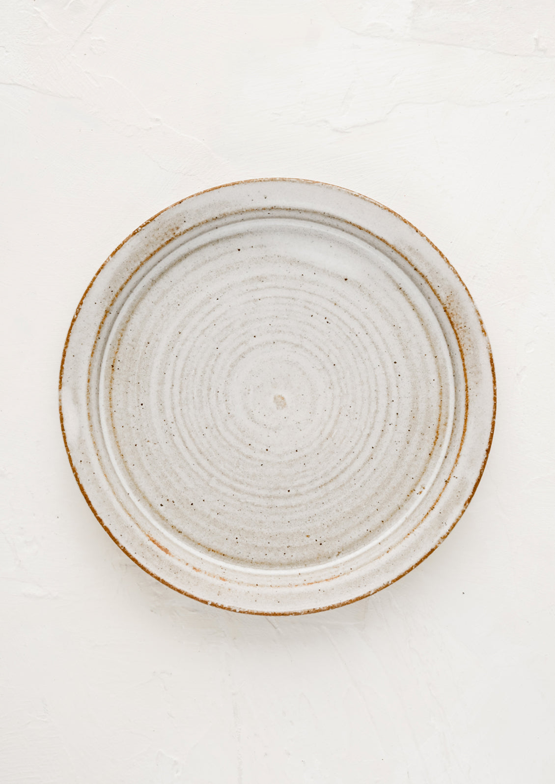 A ceramic side plate in natural rustic glaze.
