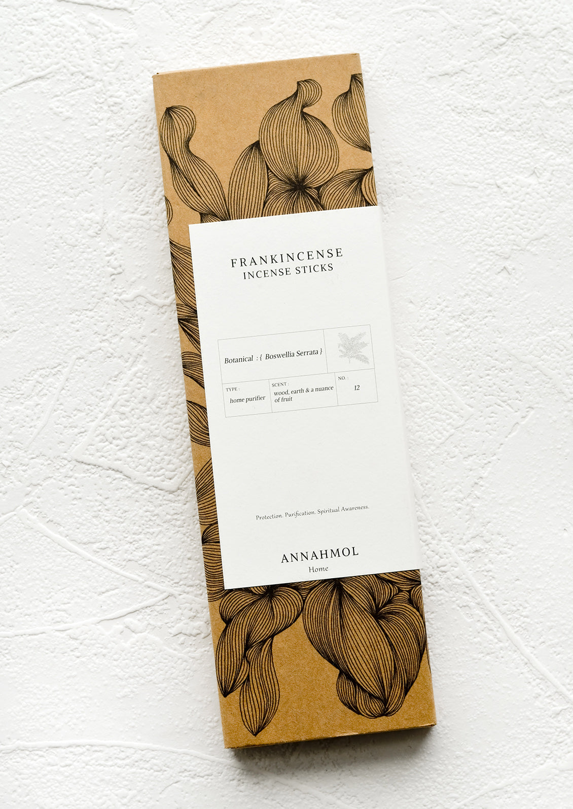 A kraft box with botanical print and white label.