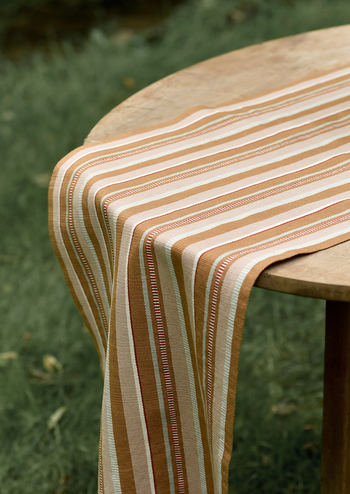 A tan striped table runner on a table.