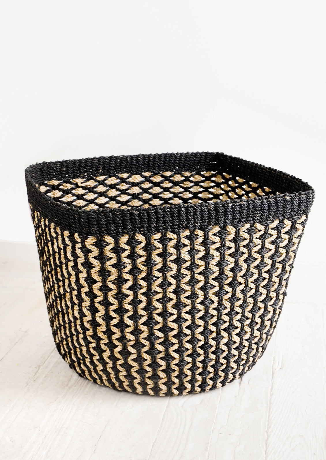 Square storage basket in black with tan zigzag design and black top rim