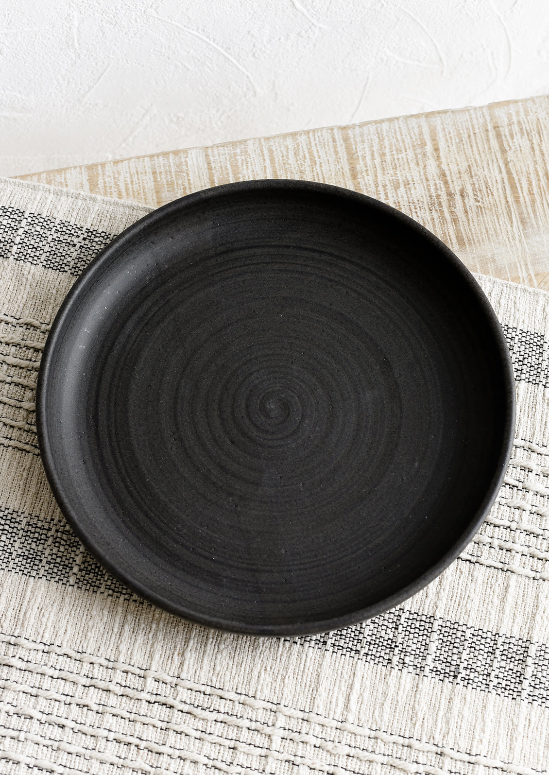A shallow serving plate in matte black.