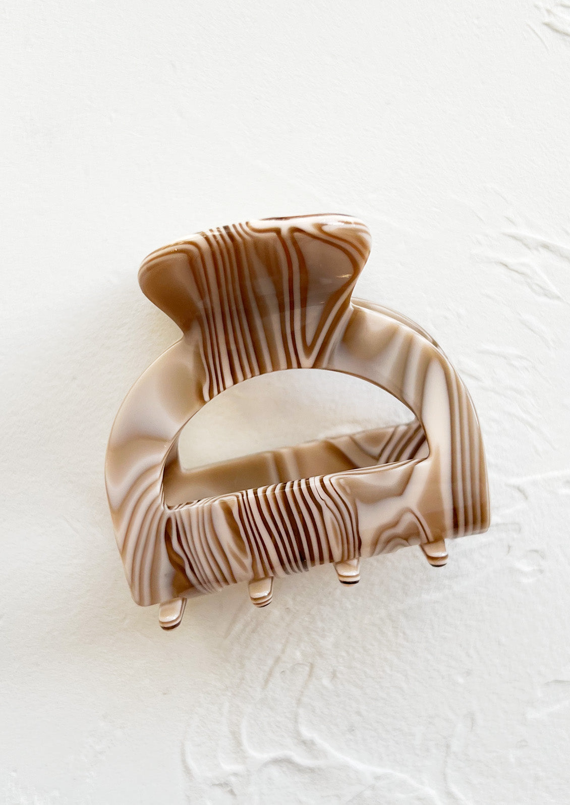 An arch shaped hair claw in mocha swirl.