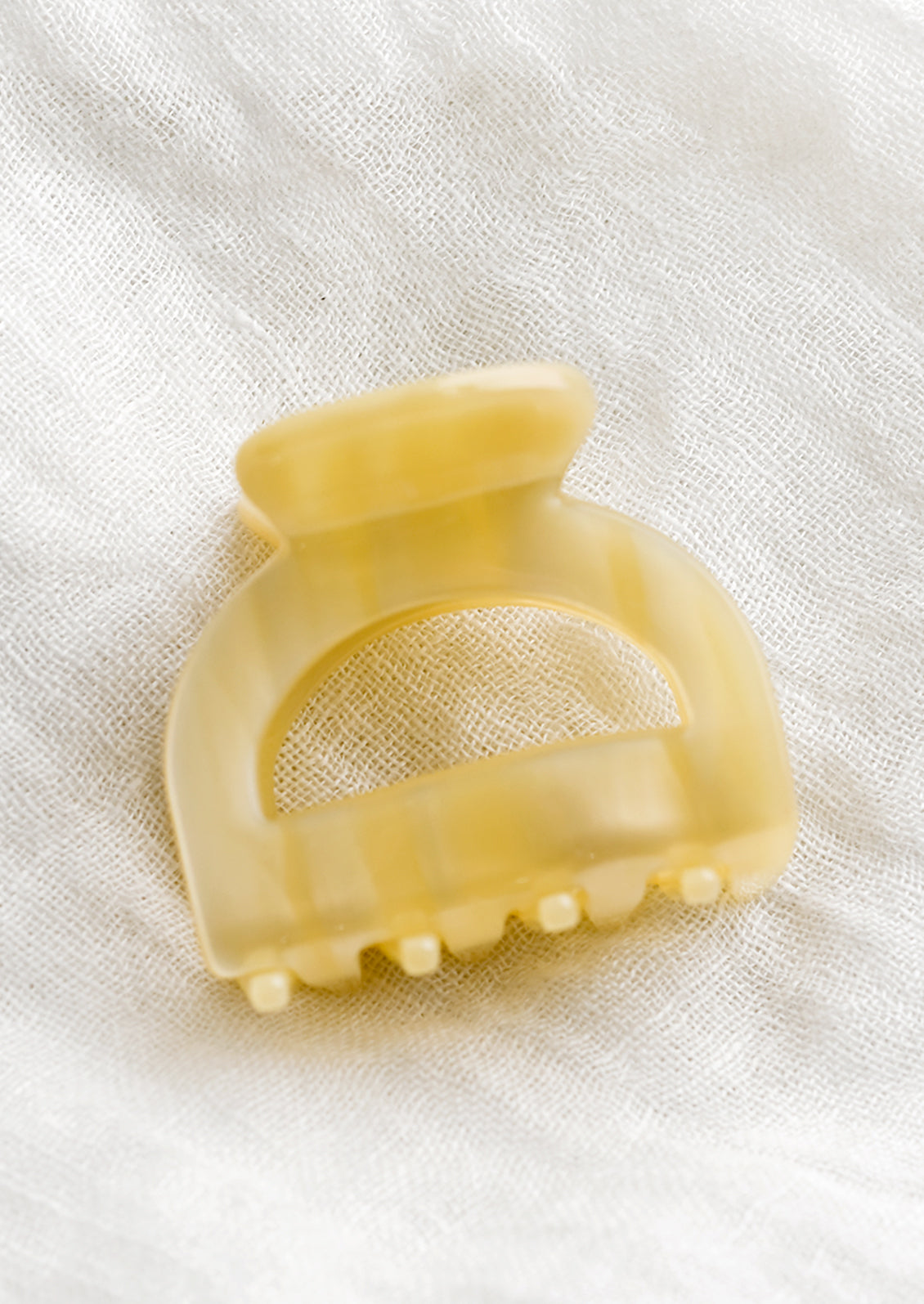An arch shaped hair claw in meringue.