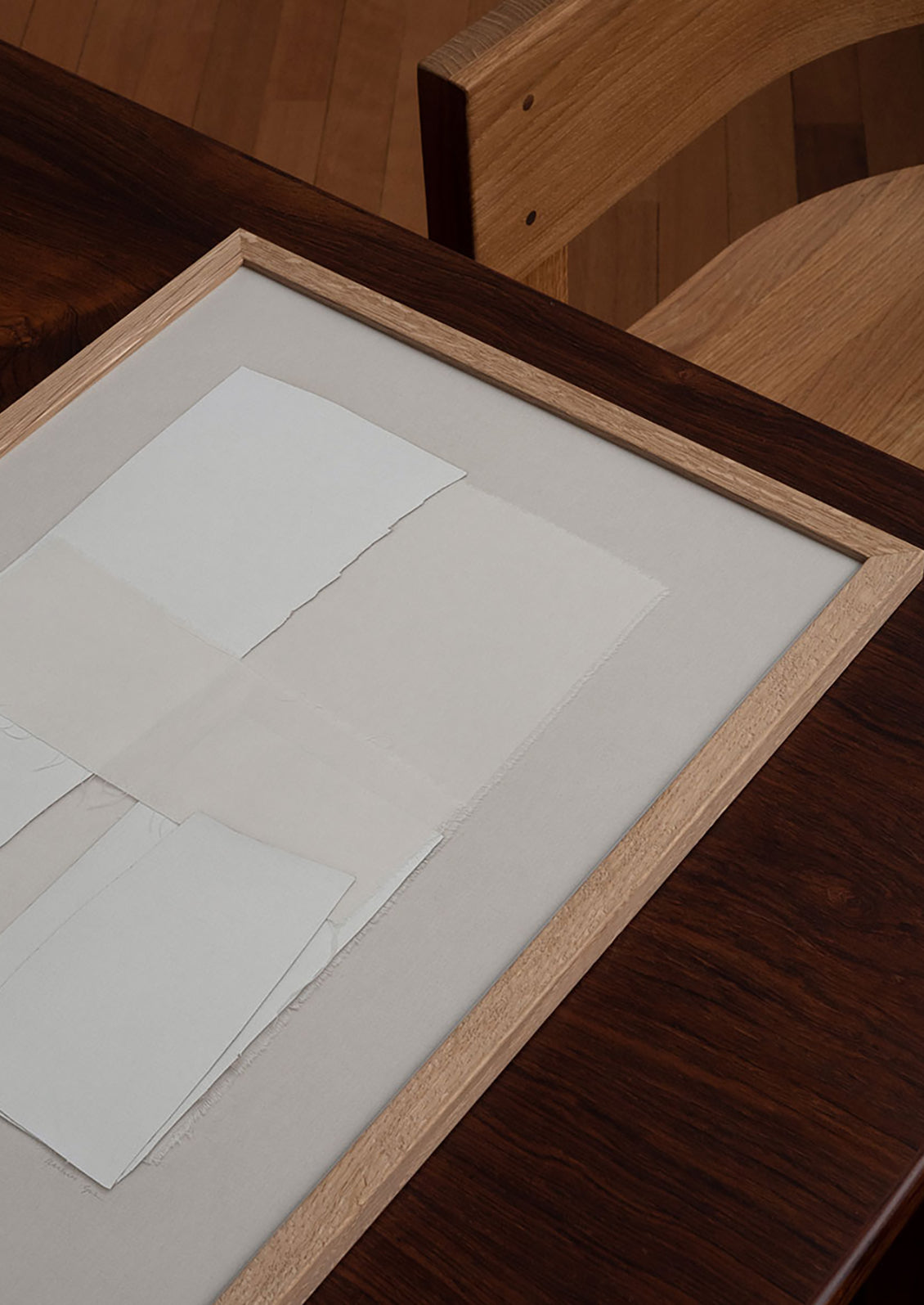 A beige art print with layered ivory textile, framed in oak frame.