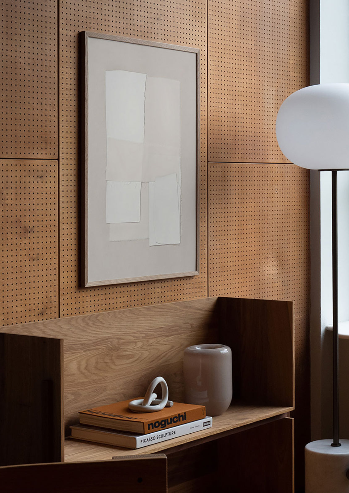 A framed textile art print on a wooden wall.