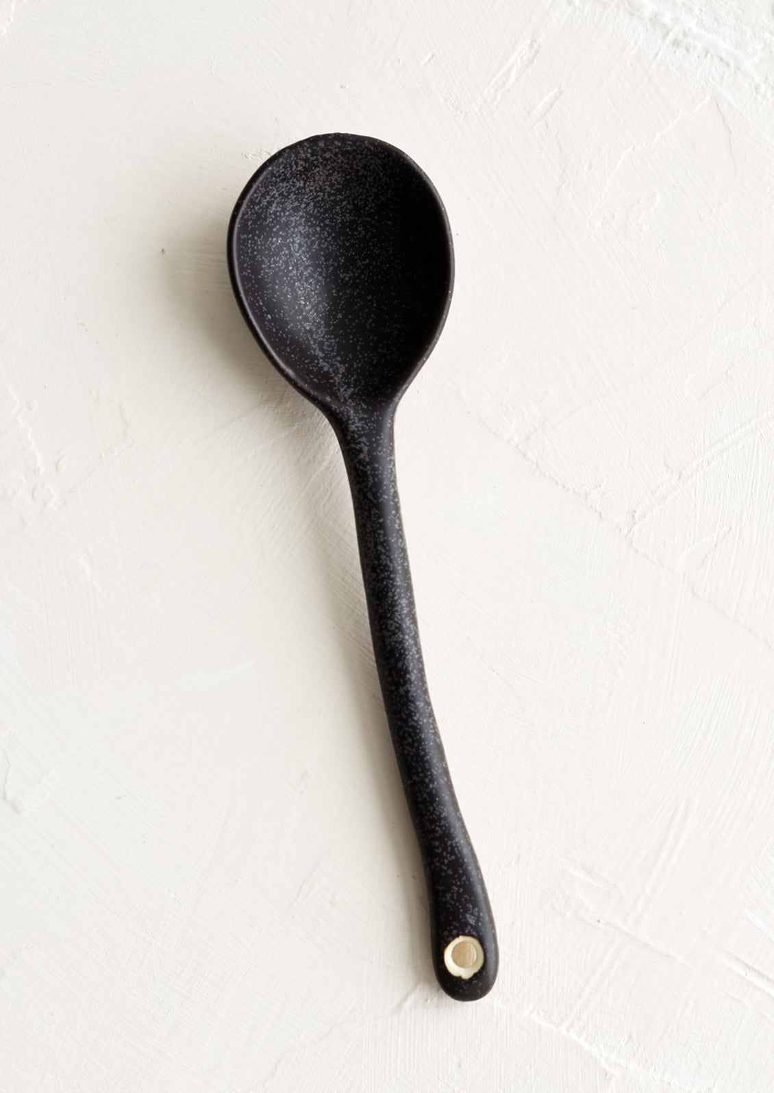 A ceramic spoon in speckled black.