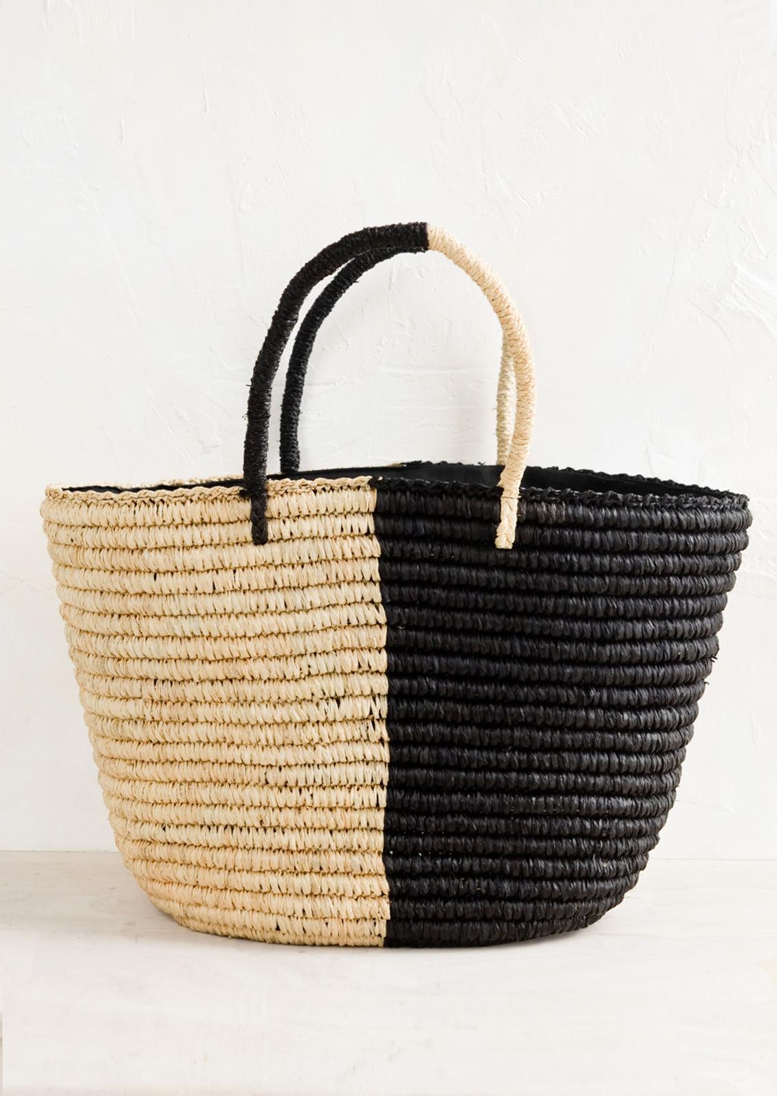 A two tone raffia tote in black and natural.