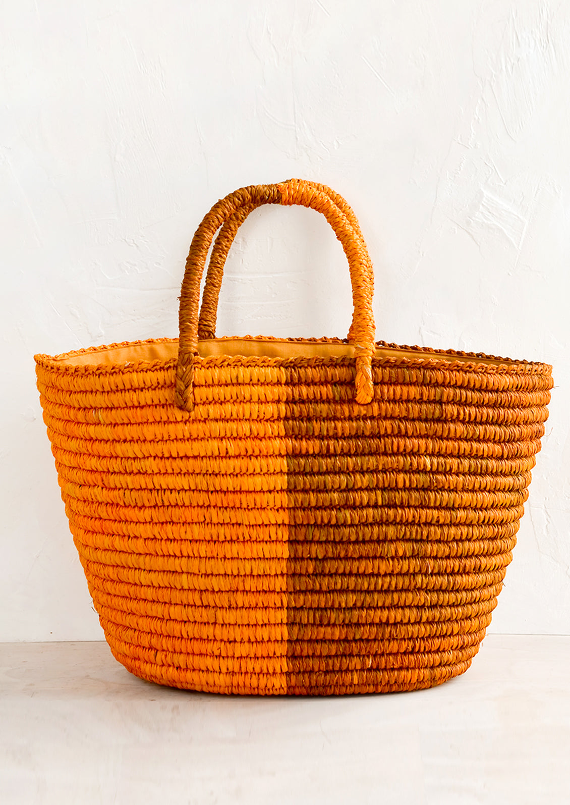 A two tone raffia tote in orange and rust.
