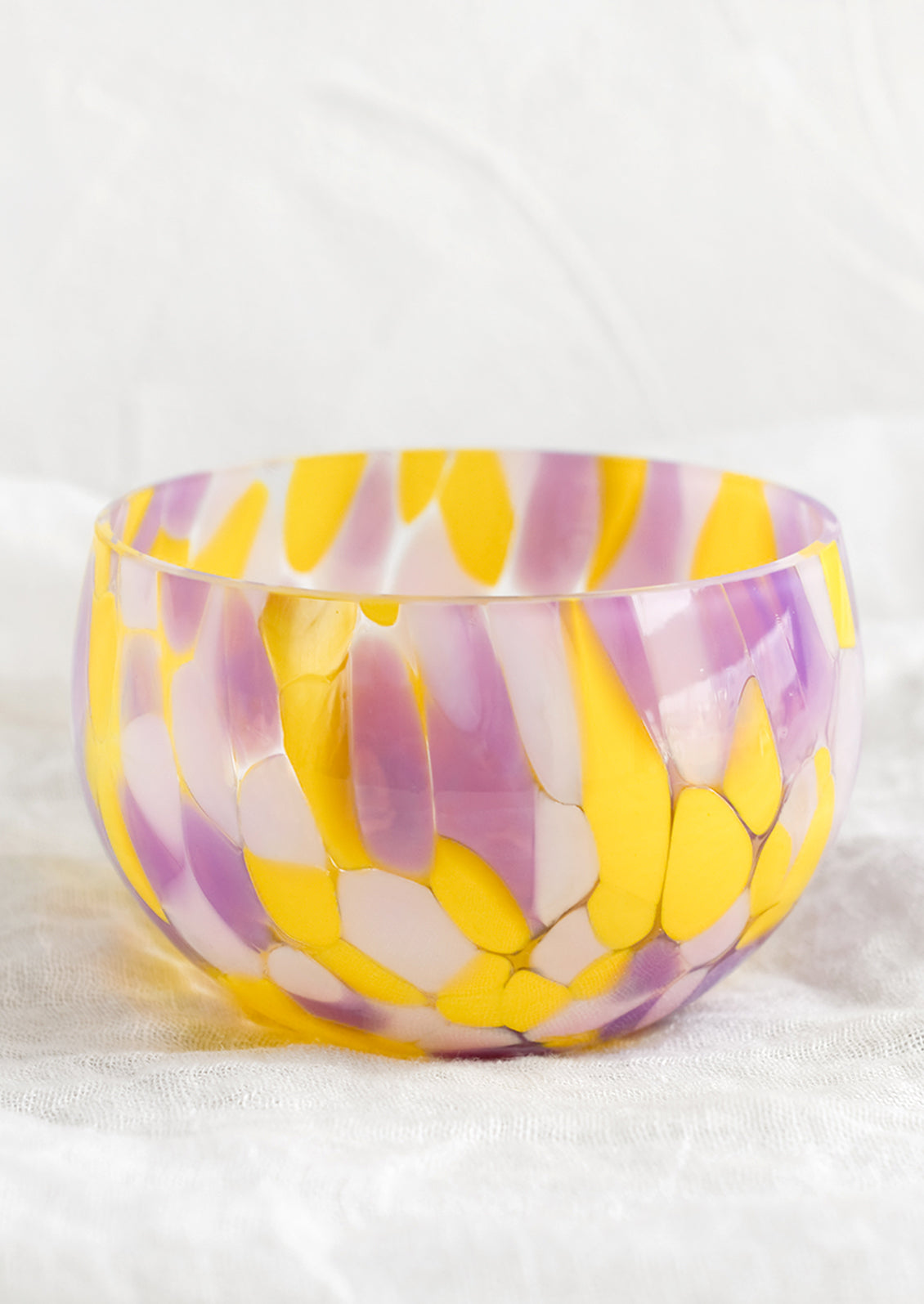 A speckled glass candy bowl in purple and yellow.