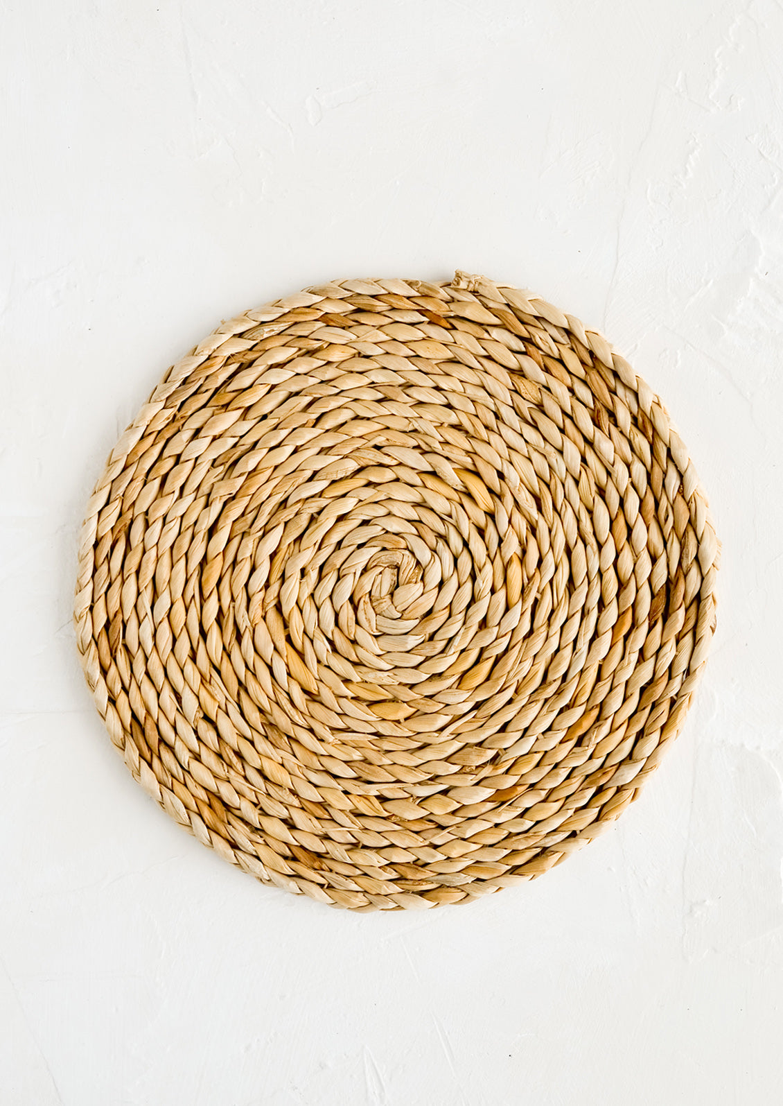 A round trivet made from woven banana bark.