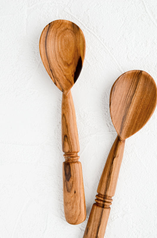 Two hand-carved spoons made from olivewood, each with its own unique grain pattern.