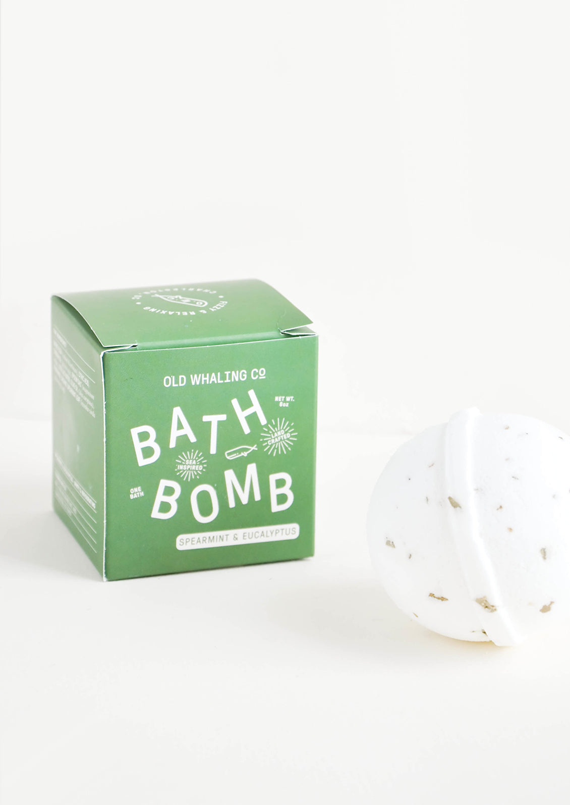 White colored, round bath bomb with green box packaging