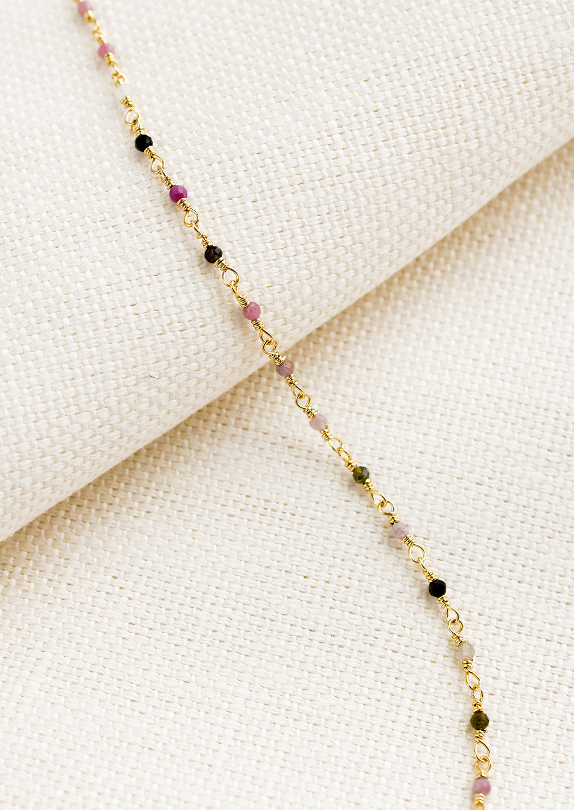 A gold wire bracelet with small multicolor tourmaline beads.