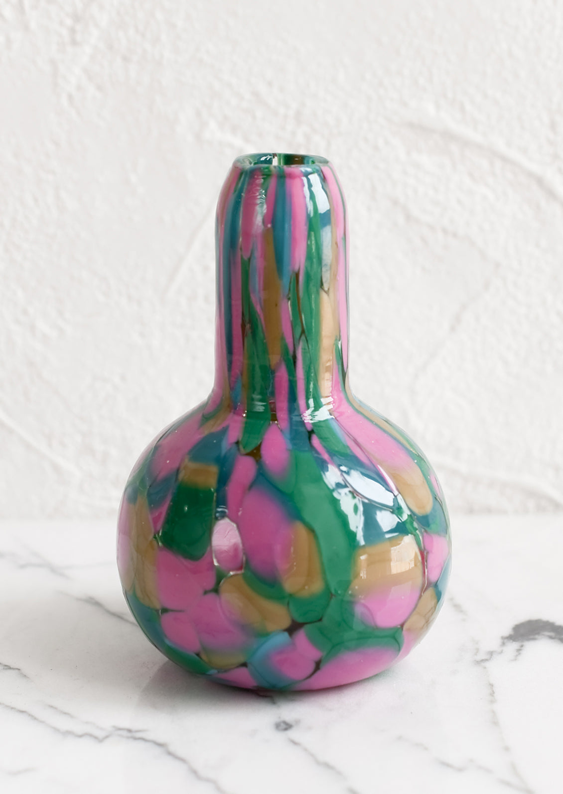 A speckled glass vase in pink, teal and green palette.
