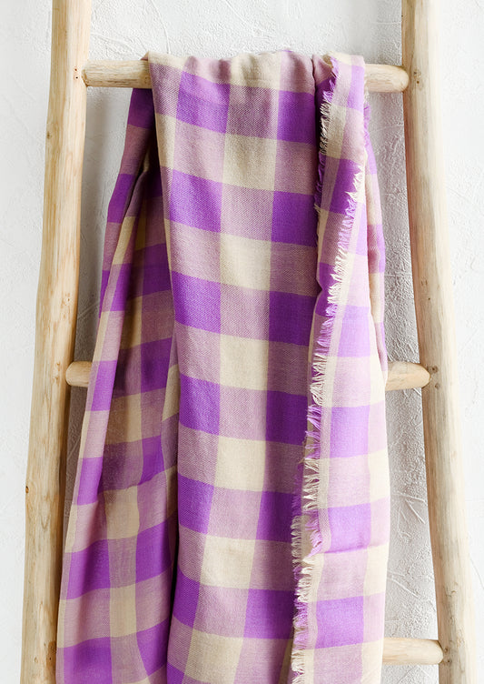 A gingham print scarf in purple and tan.
