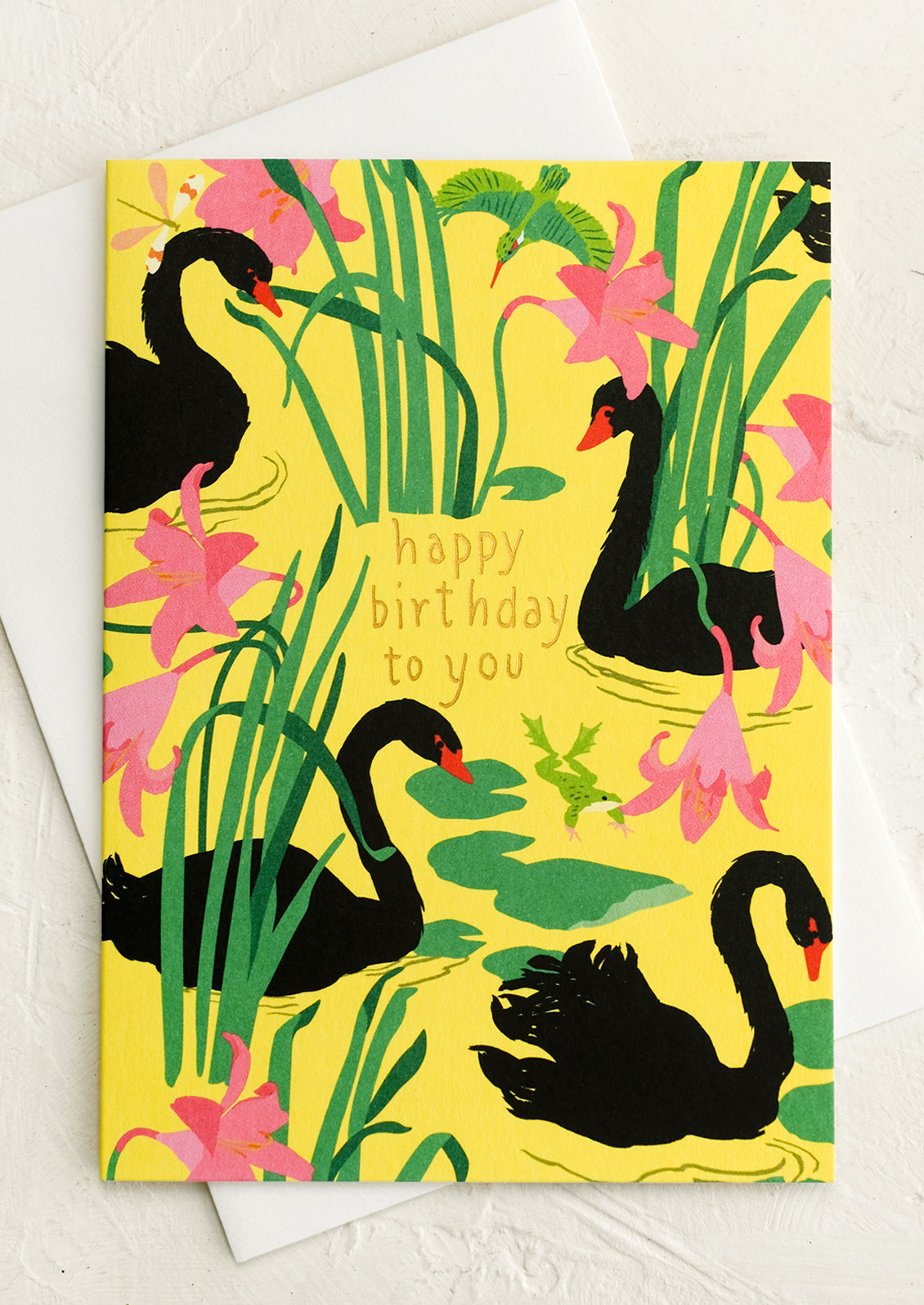 A yellow greeting card with black swan print, text reads "Happy birthday to you".