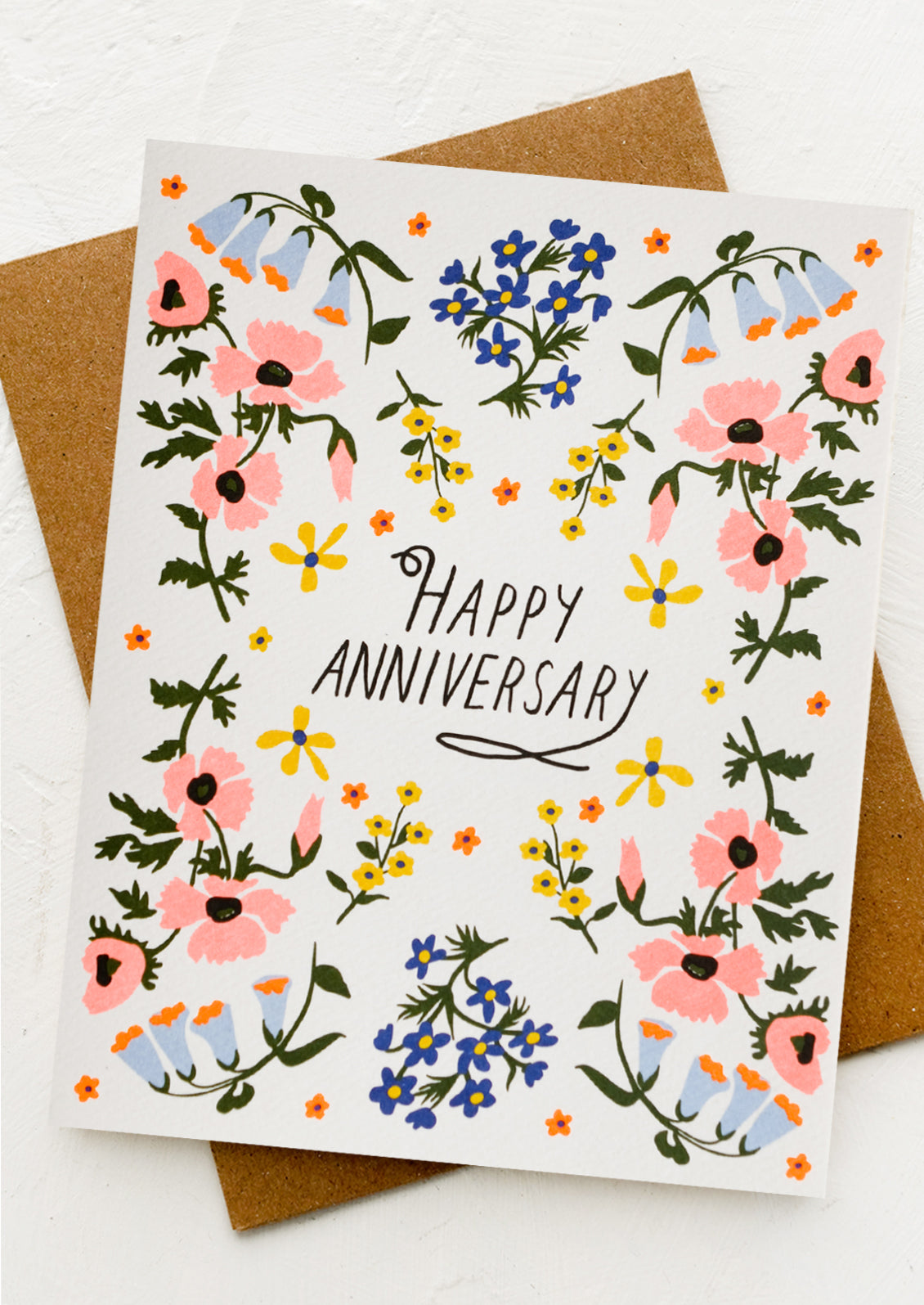 A floral print card with "Happy Anniversary" text at center.