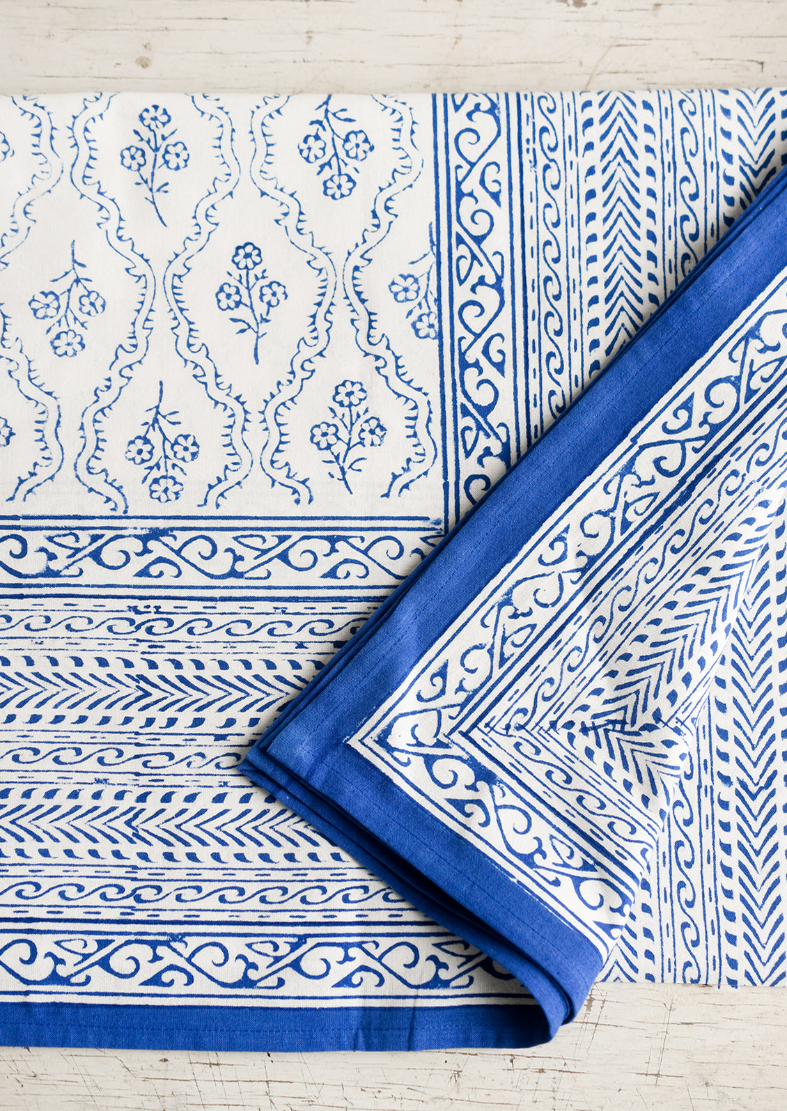 A blue and white block printed, floral print tablecloth.