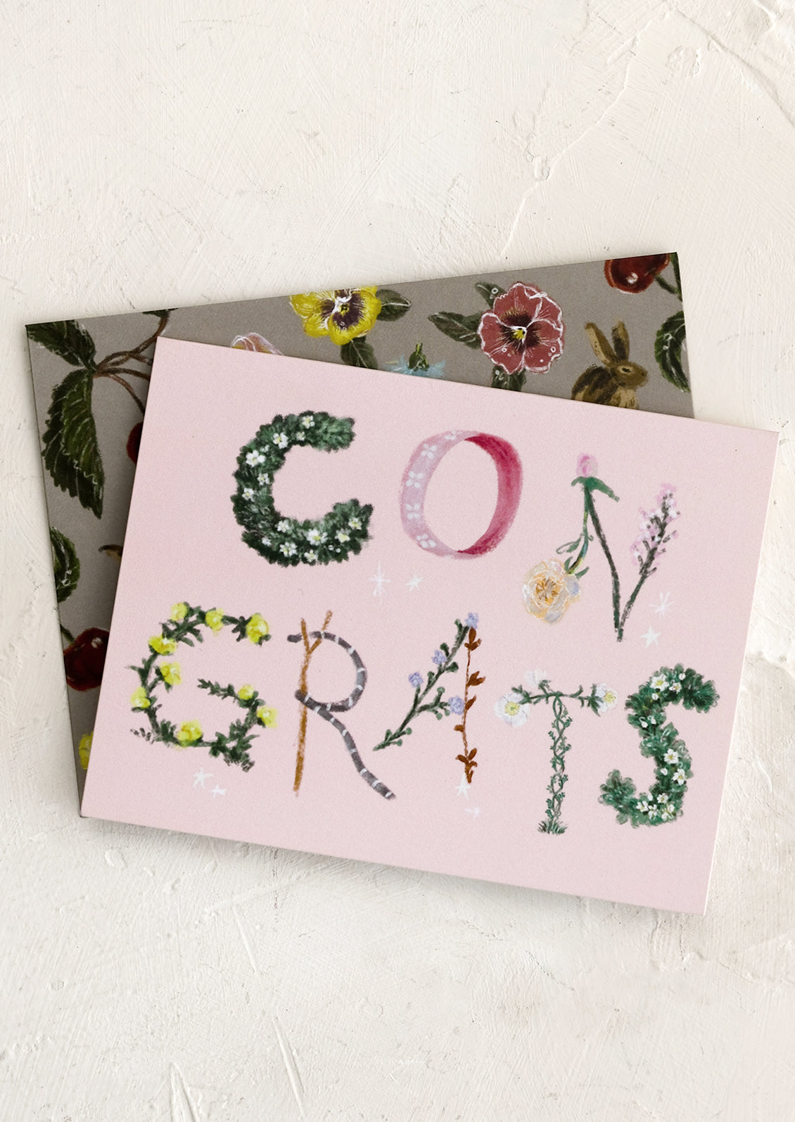 A pink congratulations card with botanical lettering.