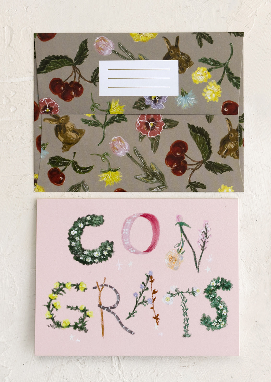 A pink congratulations card with botanical lettering.