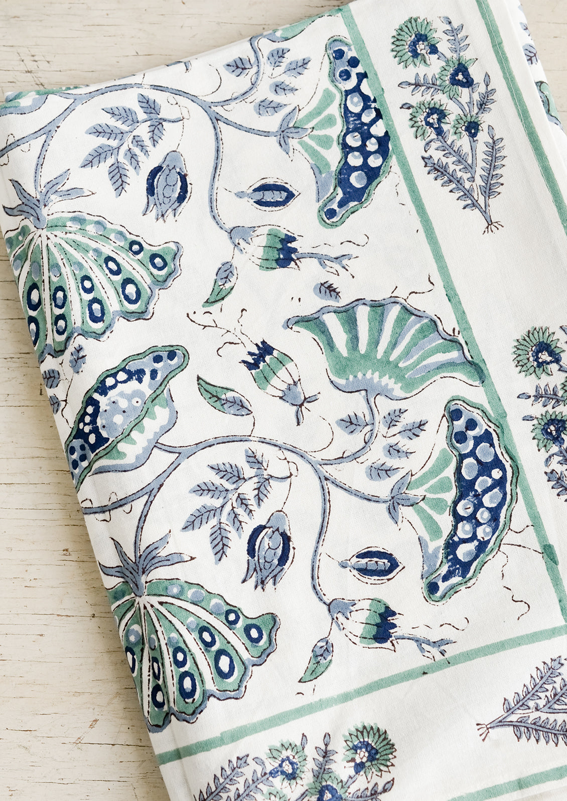 A botanical block printed tablecloth in navy and teal.