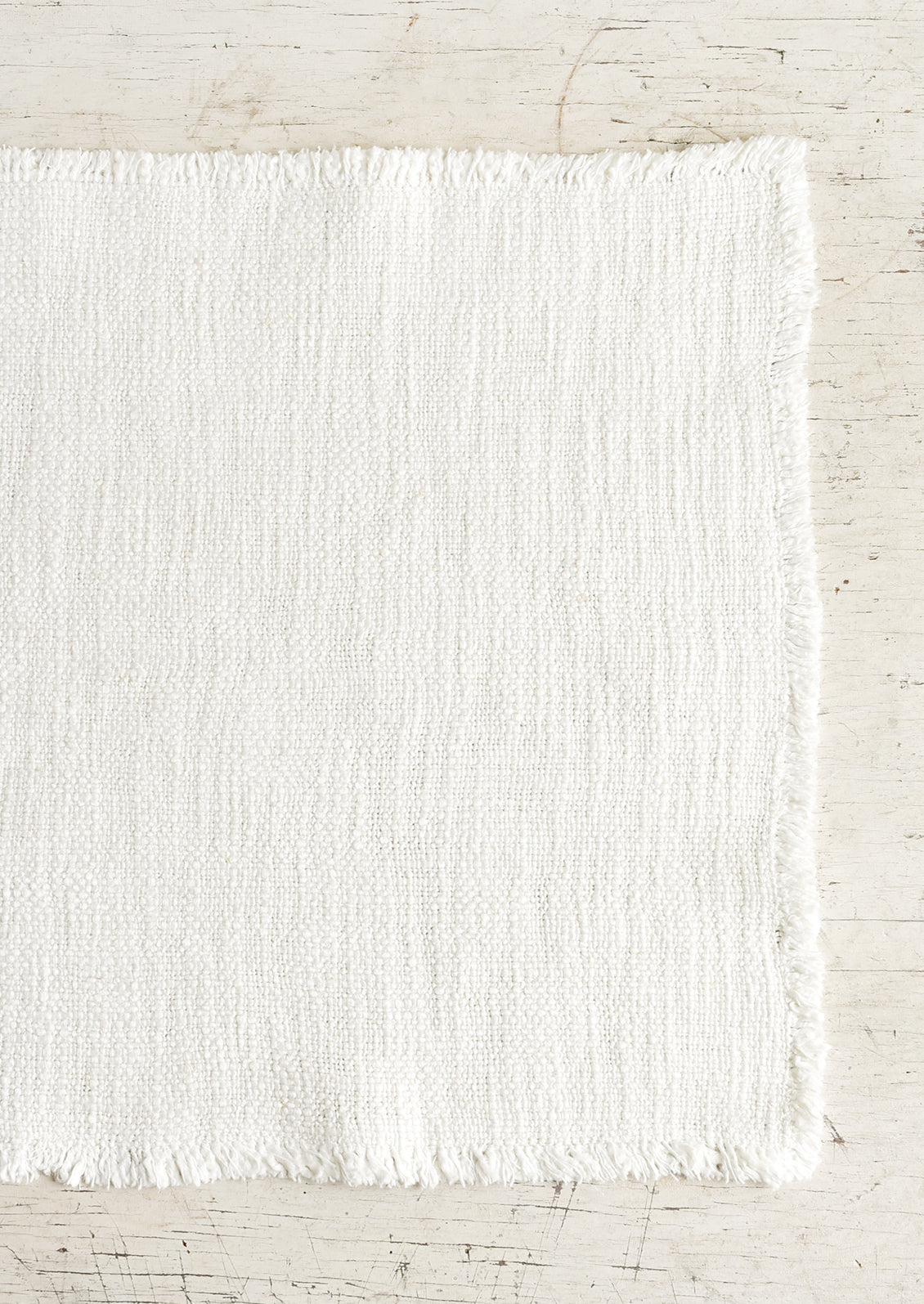 A slub boucle textured placemat in ivory.