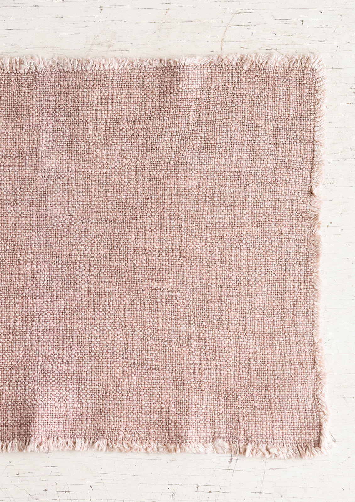A slub boucle textured placemat in dusty rose.