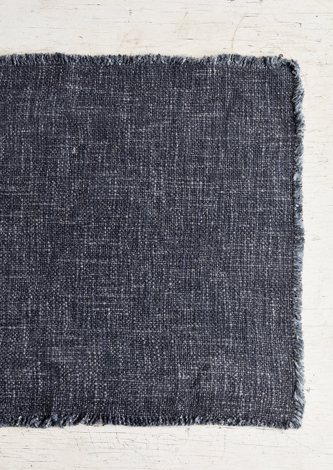 A slub boucle textured placemat in ink.