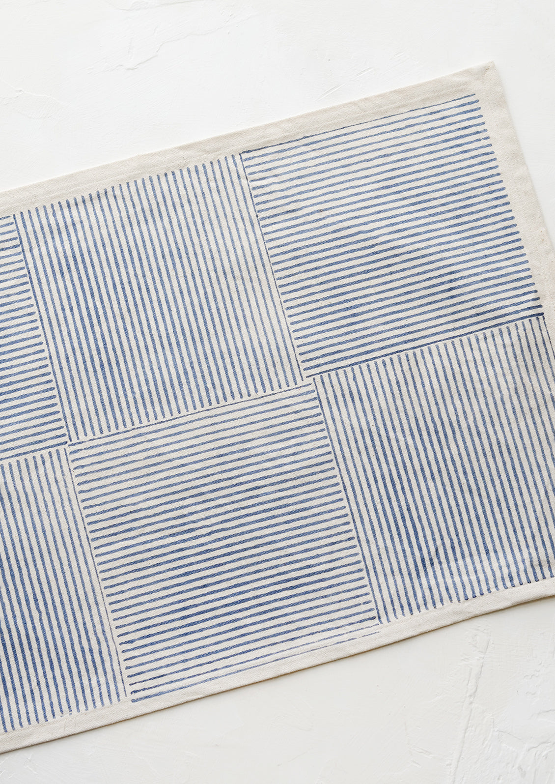 Block printed cotton placemat with boxed stripe pattern in dusty blue.