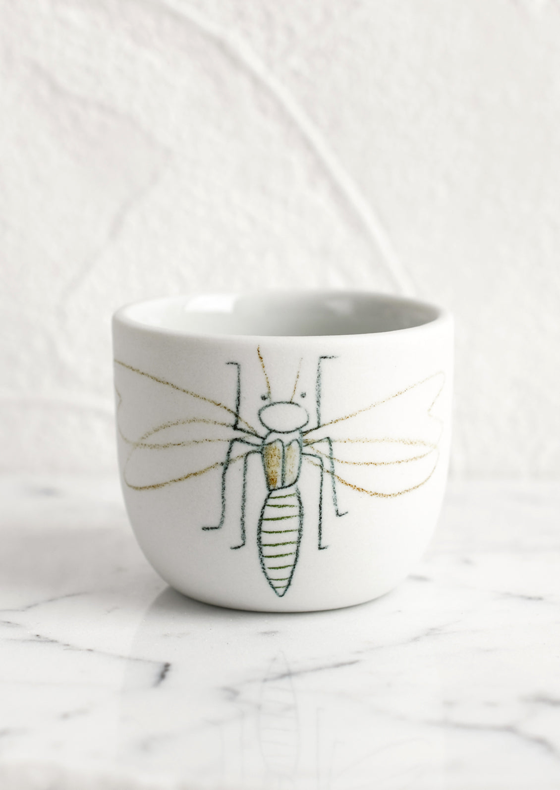 An extra small grey porcelain cup with firefly sketch.