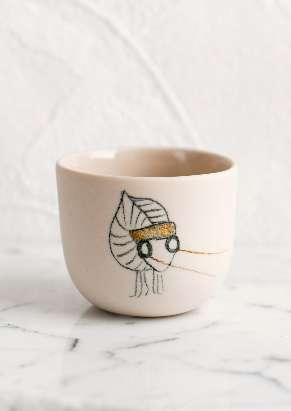 An extra small nude porcelain cup with katydid sketch.