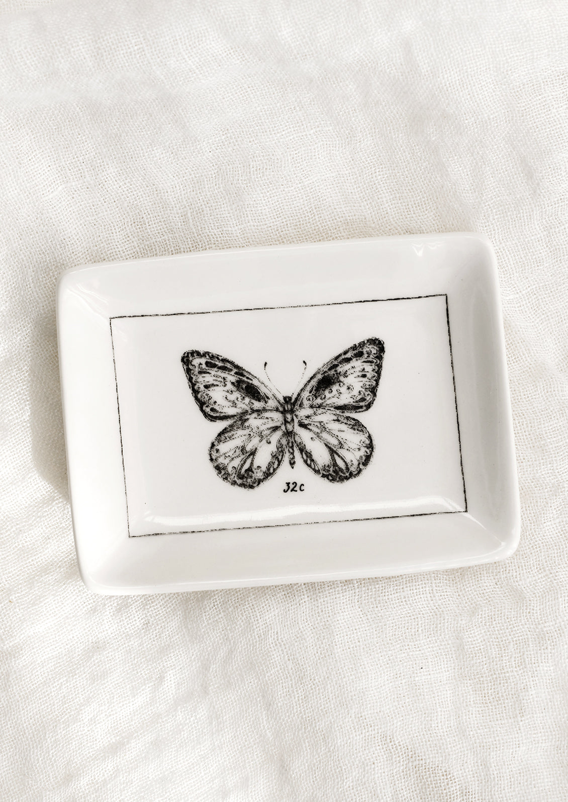 A black and white trinket dish with butterfly.