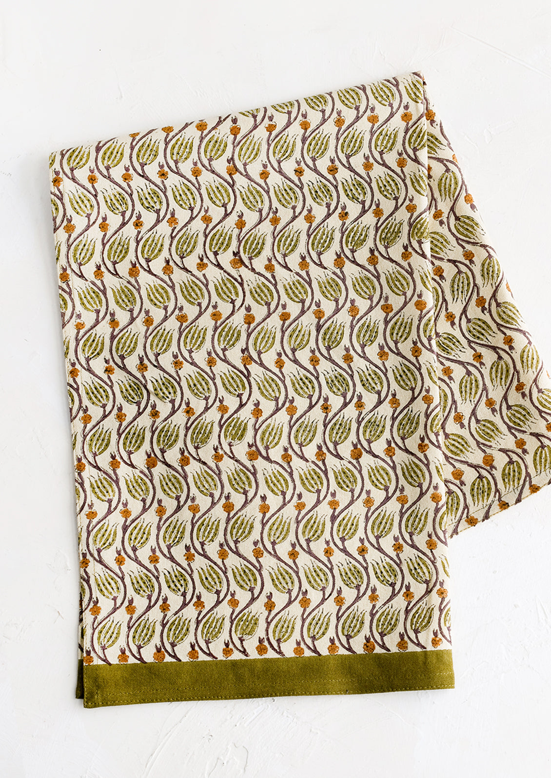 A tea towel with olive green print and trim.