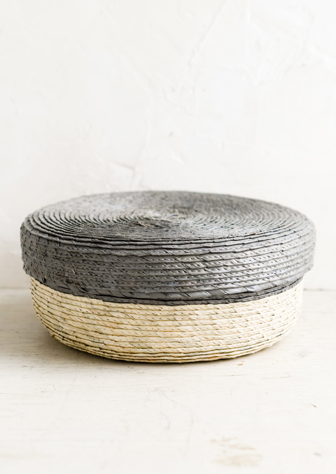 Lidded basket in the colors natural and mineral.
