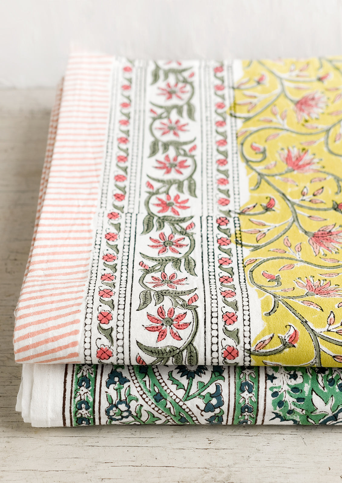 A block printed tablecloth in yellow, pink and green floral.