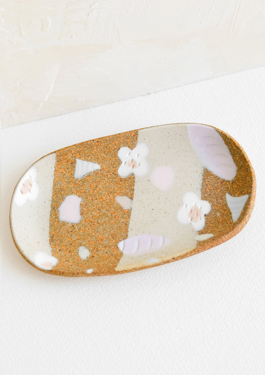 A small oval ceramic tray with pastel flower and terrazzo pattern.