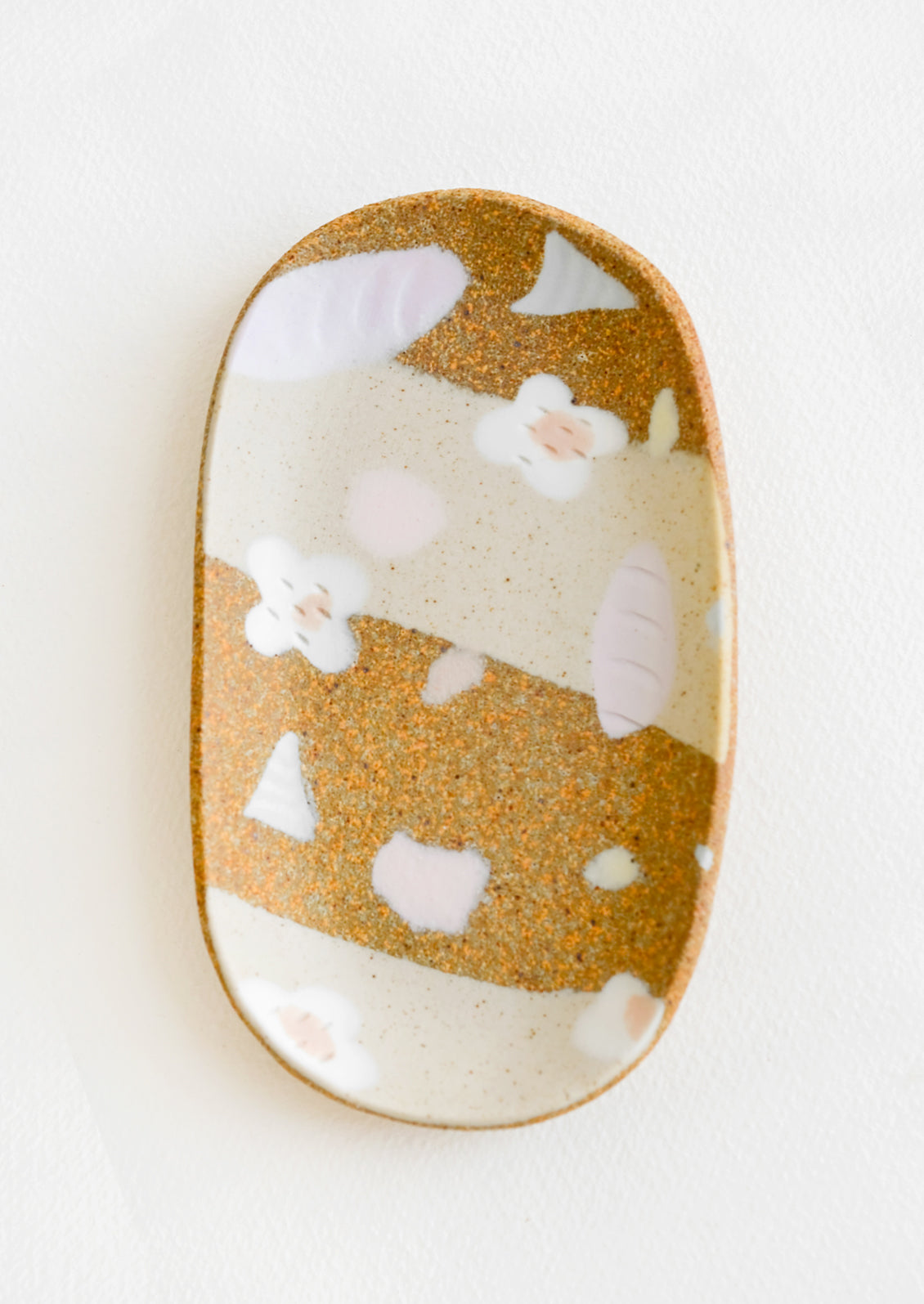A small oval ceramic tray with pastel flower and terrazzo pattern.