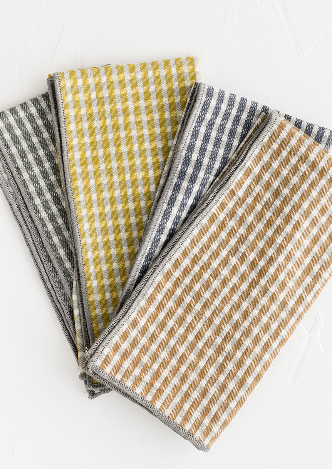 A set of four plaid print napkins in a mix of colors.