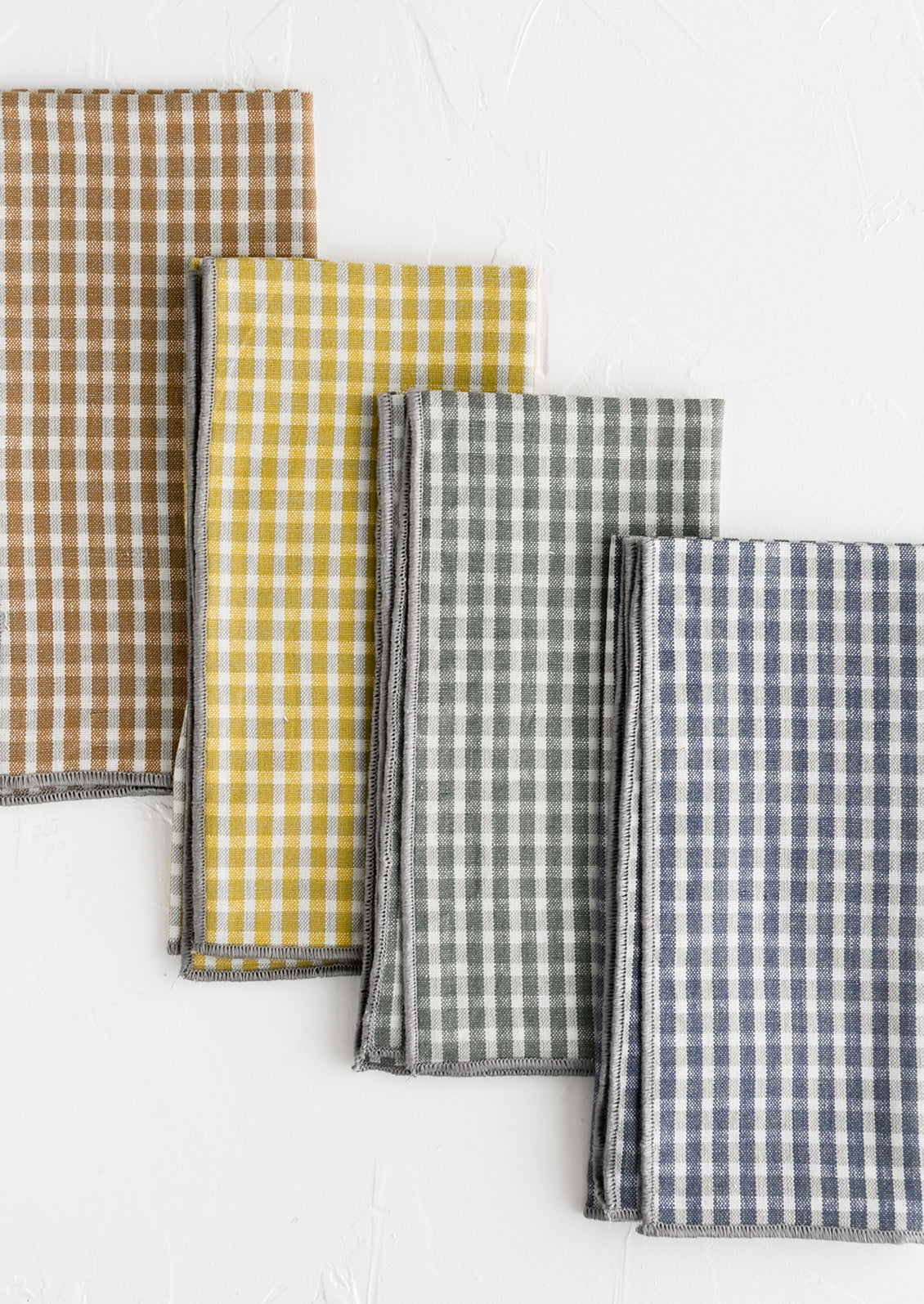 A set of four plaid print napkins in a mix of colors.