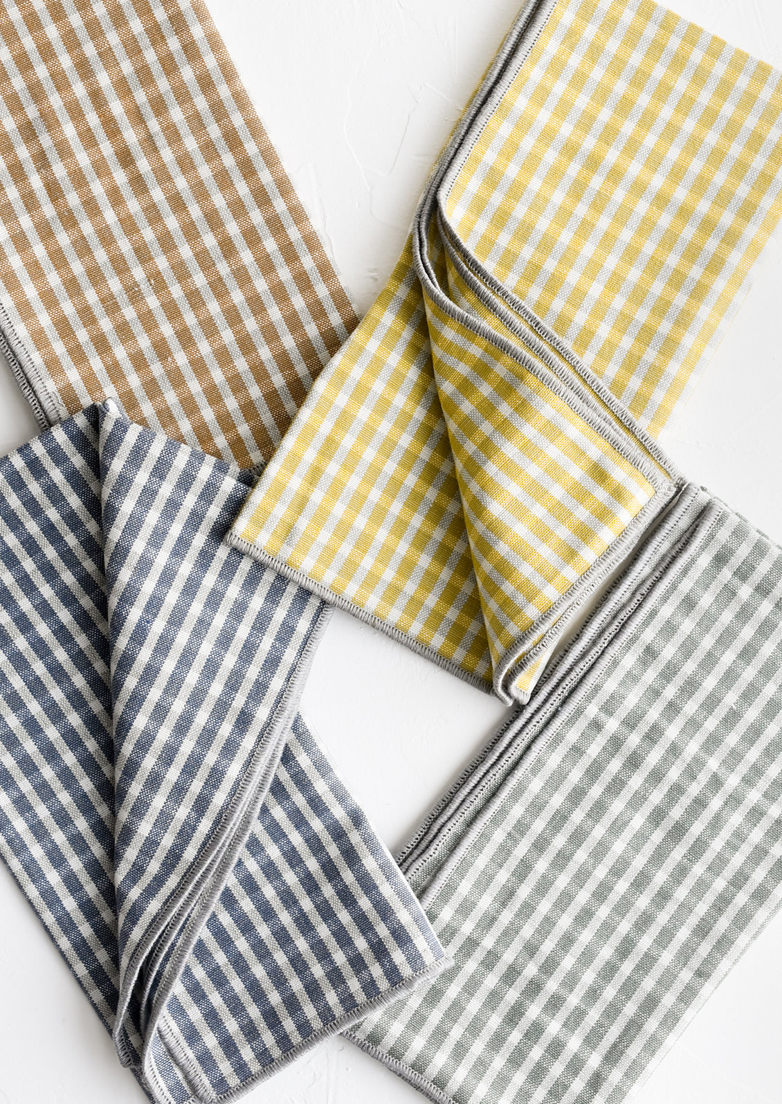 A set of four plaid print napkins in a mix of colors.