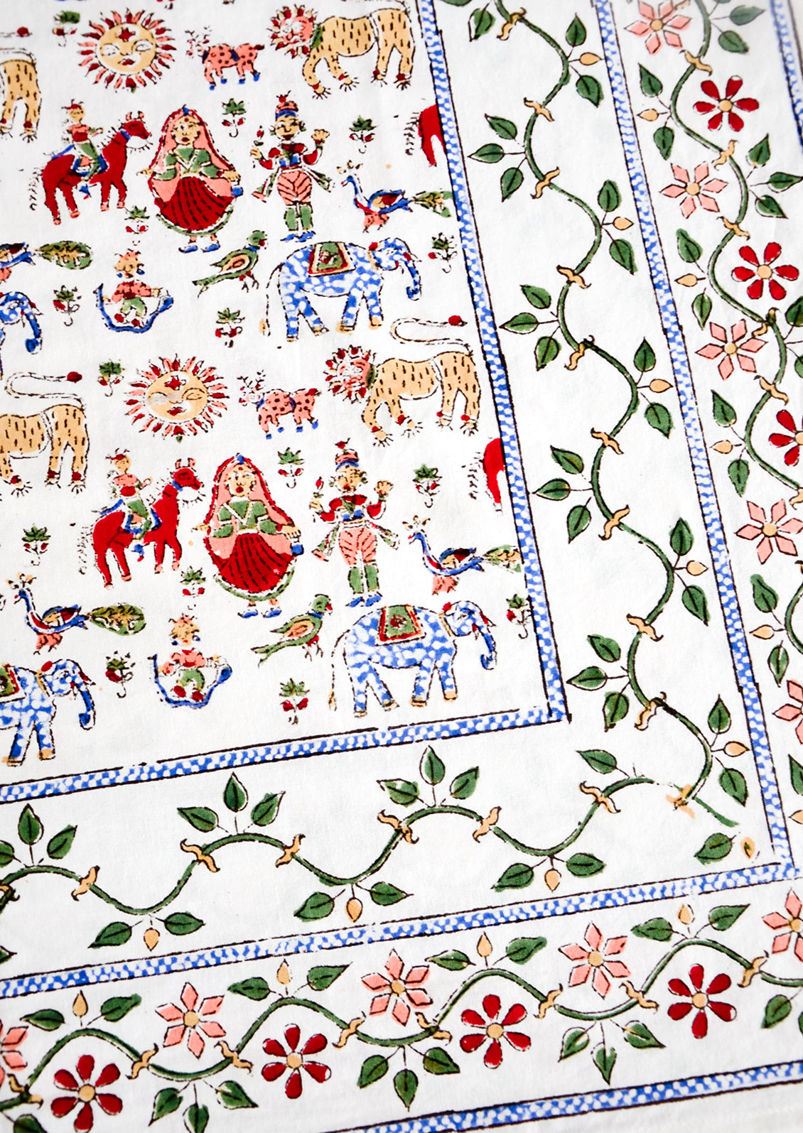 Block printed, folk carnival print in blue, green and red on white cotton.