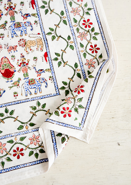 White cotton tablecloth with multicolor, block printed folk carnival themed print