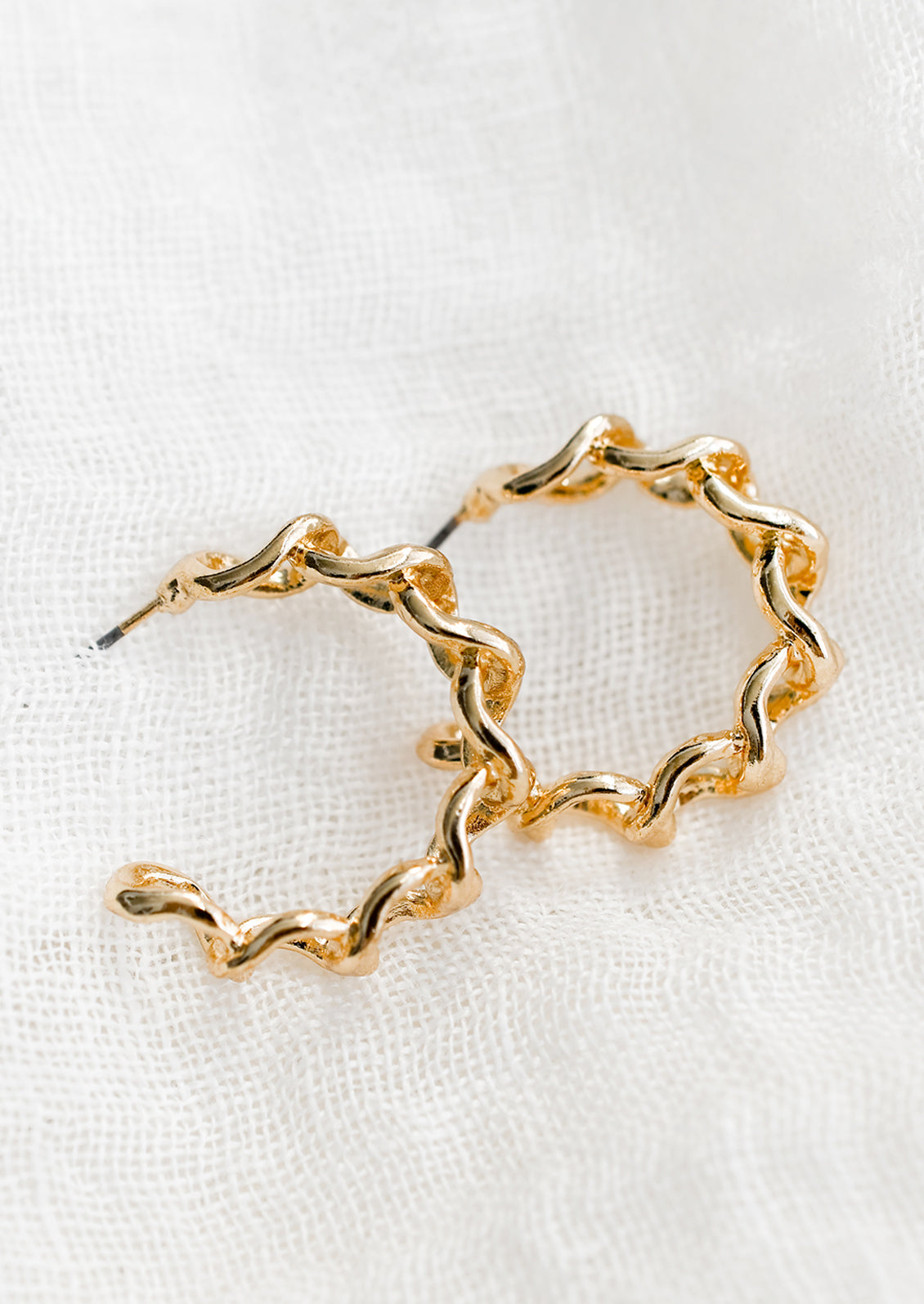 A pair of chainlink hoop earrings in gold.