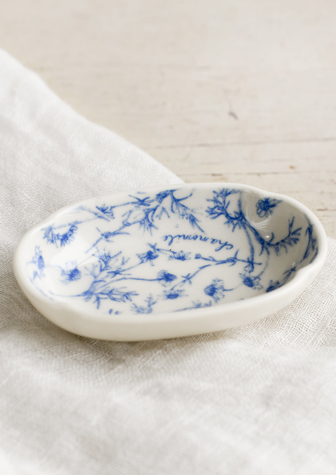 A small oval shaped dish in white with blue floral pattern.