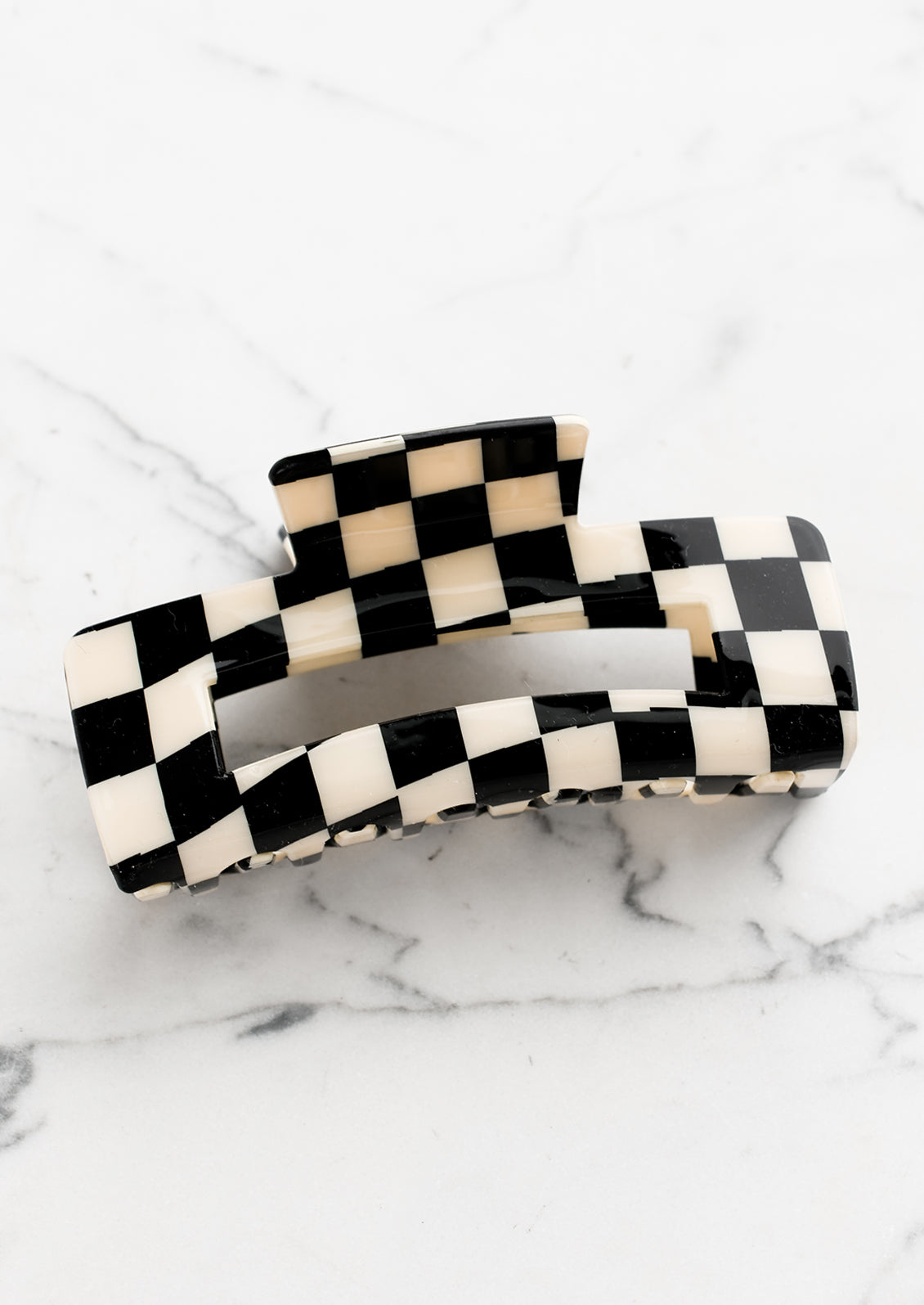 A checker print hair claw in black and ivory.